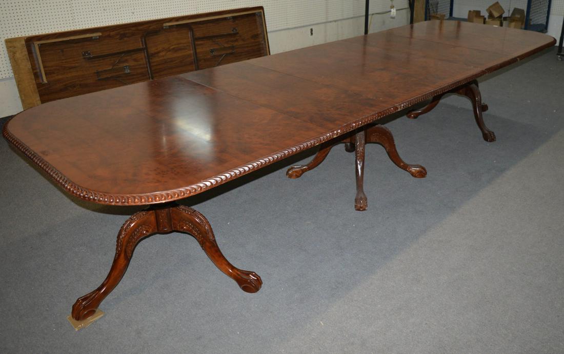 Chippendale-style mahogany dining table: "Surrey House" Chippendale-style mahogany triple-pedestal dining table, the cross-banded rectangular top with gadroon-carved edge; on acanthus-carved balusters and tripods with ball-and-claw feet; fit