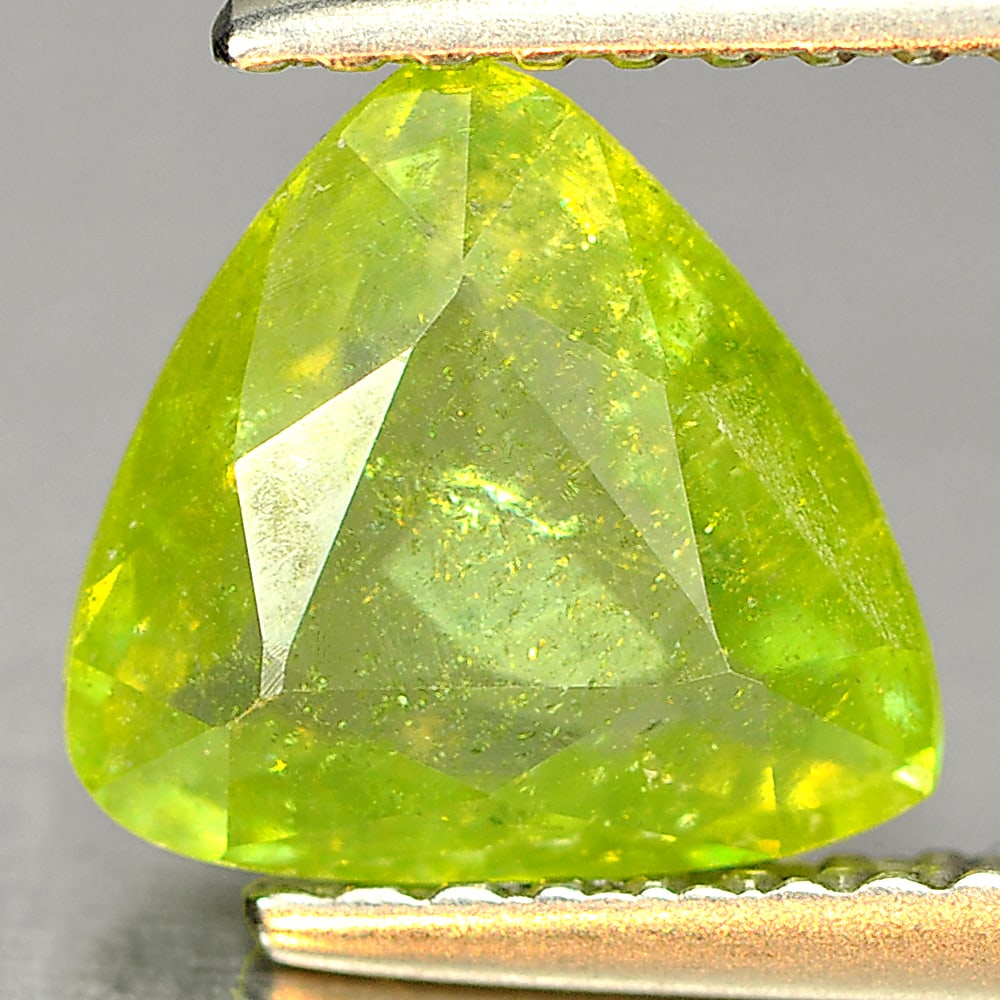 Green Titanium Natural Sphene With Rainbow Spark 1.24 Ct. Trilliant Shape 7.8 x 7.6 Mm Gemstone From: Product ID: 806507873 Product Name: Natural Sphene Weight: 1.24 CT. Size: 7.8 x 7.6 x 2.7 MM. Shape: Trilliant Color: Green With Rainbow Spark Clarity:SI1 Luster: Good Gems Origin: Madagascar Treatmen