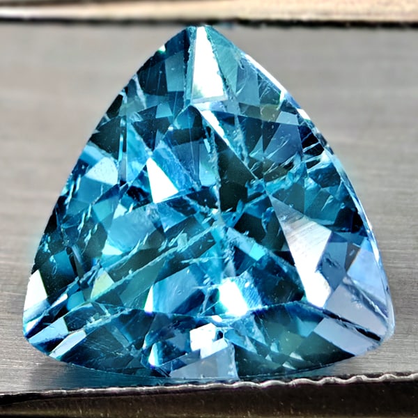 Natural Swiss Blue Topaz 5.12 Ct. Trilliant Shape 10.8 Gemstone From Brazil: Product ID: 807167919 Product Name: Natural Blue Topaz Weight: 5.12 CT. Size: 10.8 x 10.8 x 7.2 MM. Shape: Trilliant Color: Swiss Blue Clarity:VSI Luster: Good Gems Origin: Brazil Treatment: Treated C