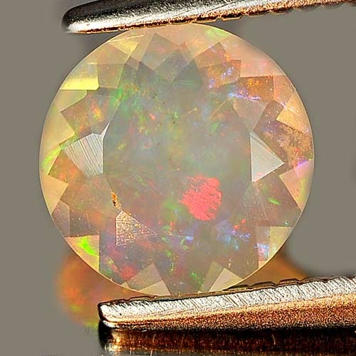 Natural Multi Color Play Of Colour Opal 0.48 Ct. Round Shape 6.6 Mm Gemstone From Ethiopia: Product ID: 818725901 Product Name: Natural Opal Weight: 0.48 CT. Size: 6.6 x 6.6 x 2.9 MM. Shape: Round Color: Multi Color Clarity:Semi - Transparent Luster: Strong Iridescent Gems Origin: Ethiopia T