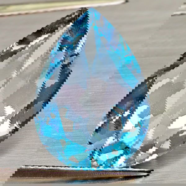 Natural Swiss Blue Topaz 14.40 Ct. Pear Shape 18.1 x 13.1 Mm Gemstone From Brazil: Product ID: 807168010 Product Name: Natural Blue Topaz Weight: 14.40 CT. Size: 18.1 x 13.1 x 8.8 MM. Shape: Pear Shape Color: Swiss Blue Clarity:VSI - SI1 Luster: Good Gems Origin: Brazil Treatment: T