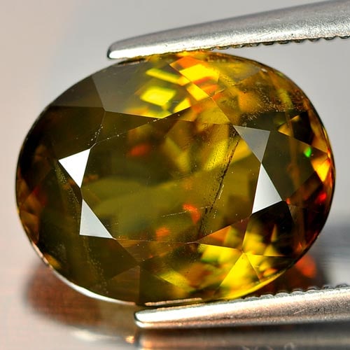 Natural Multi Color Titanium Sphene Red Spark 6.18 Ct. Oval Shape 12 x 9.4 Mm. Unheated Gemstone: Product ID: 806504111 Product Name: Natural Sphene Weight: 6.18 CT. Size: 12 x 9.4 x 5.4 MM. Shape: Oval Color: Multi Color With Red Spark Clarity:VSI Luster: Adamantine Gems Origin: Mardagascar Treat