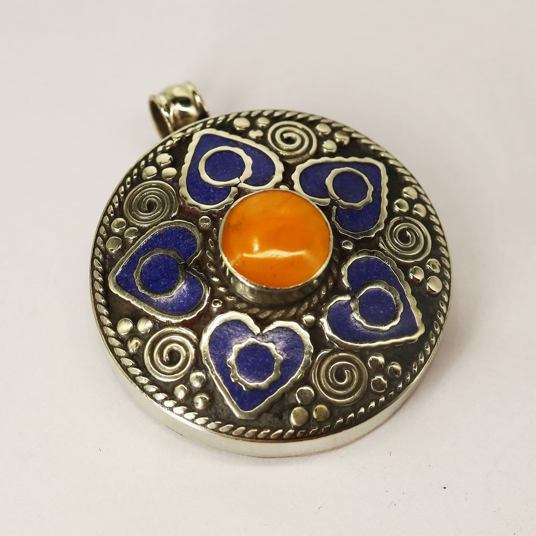 Afghani Natural Lapis Heart Ethnic Pendant: Product ID: 250804182728Product - Tibetan Handmade PendantGemstone - Natural Lapis & CopalSize - 4.2X4.2 CM RoundWeight - 42 GramMetal - Brass & Copper mix MetalOrigin - NepalCountry/Region of Manufac
