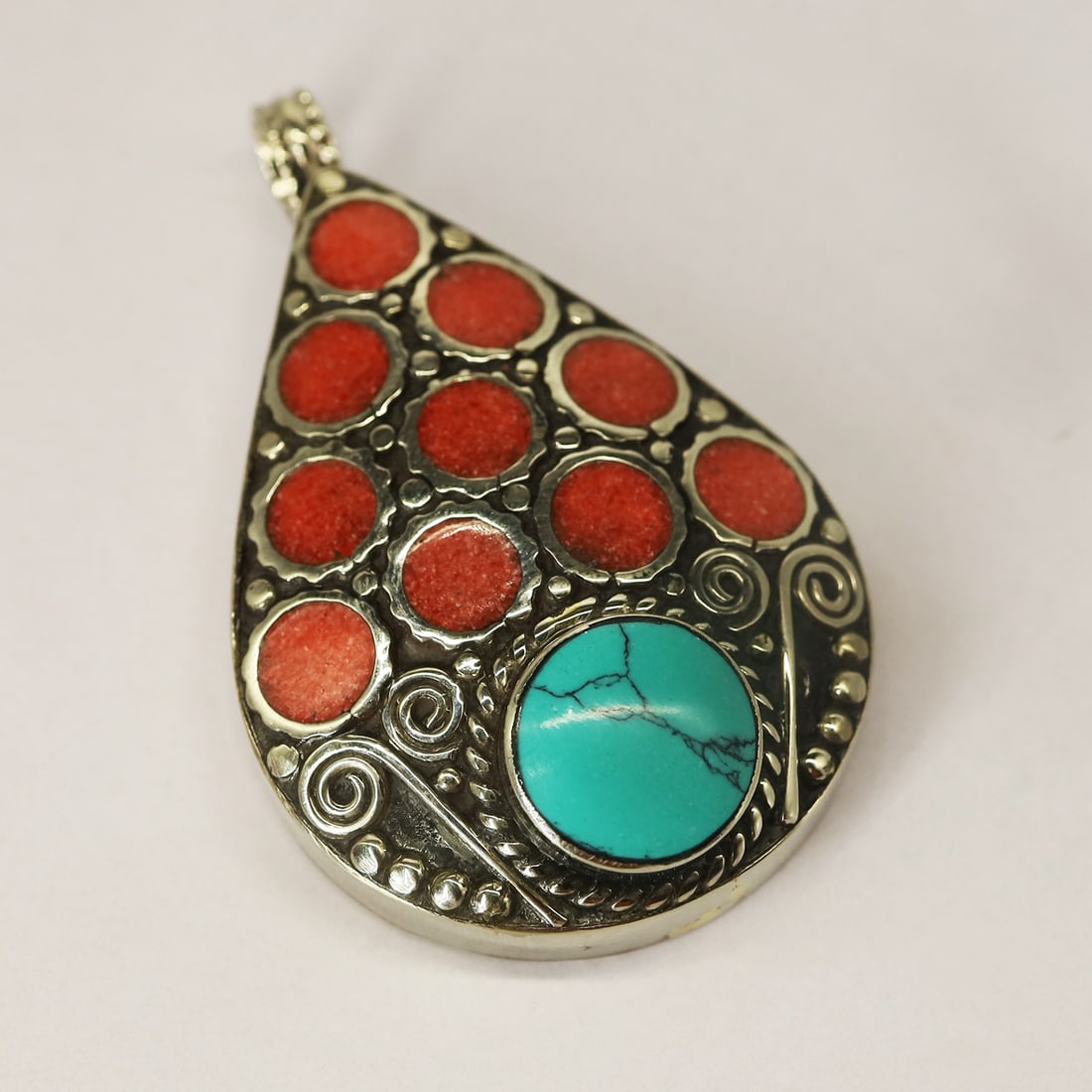 Tibetan Turquoise & Coral Handmade Pendant: Product ID: 250804125204Product - Tibetan Handmade Pendant Size - 5X3.5 CM Weight - 39 Gram Metal - Brass & Copper mix Metal Origin - Nepal Country/Region of Manufacture - Nepal At Your Service: At Tr