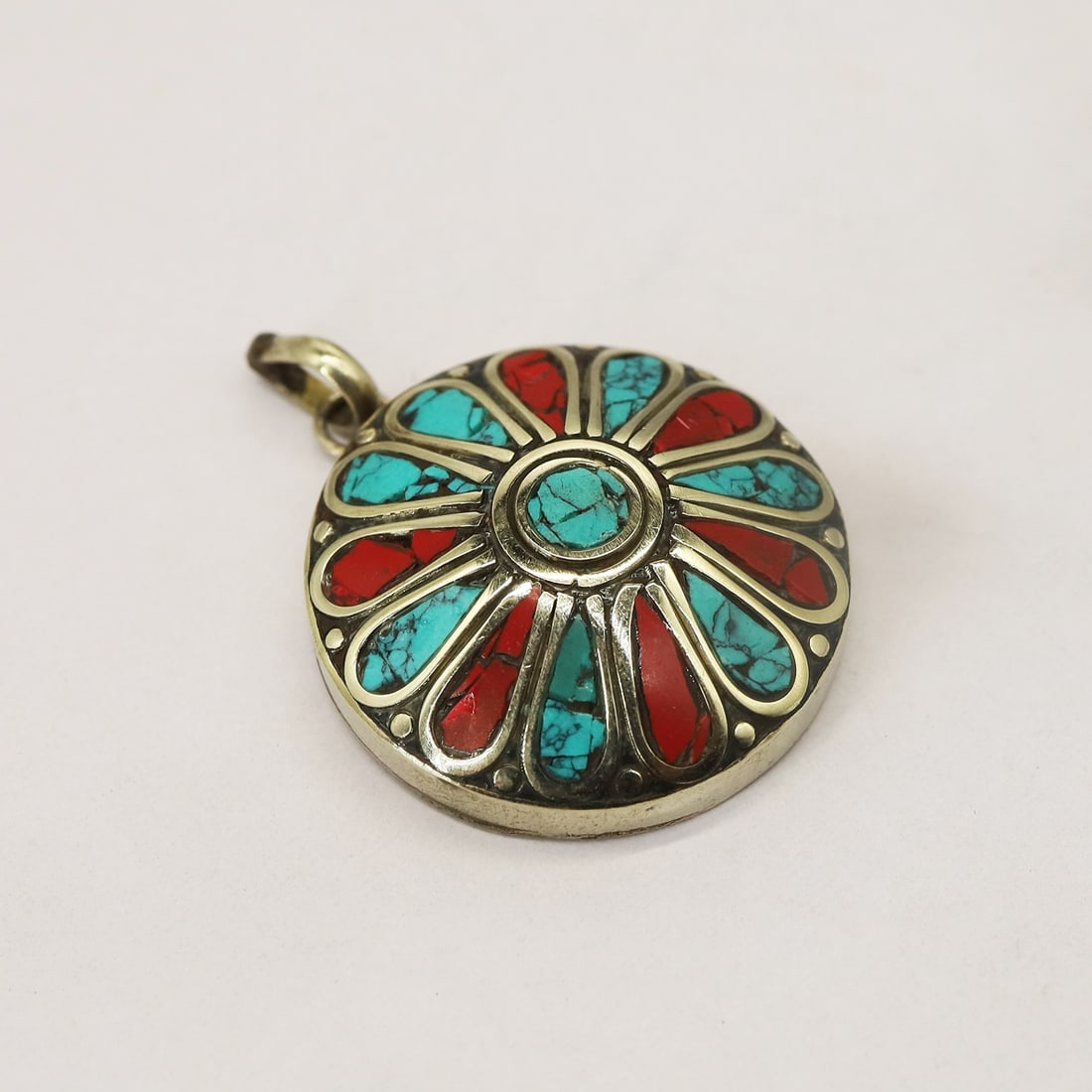 Tibetan Turquoise & Coral Handmade Round Pendant: Product ID: 250816140557 Product - Tibetan Handmade Pendant Gemstone - Natural Turquoise & Coral Size - 3x3 Cm Weight - 15 Gram Metal - Brass & Copper mix Metal Origin - Nepal Country/Region of Manufa