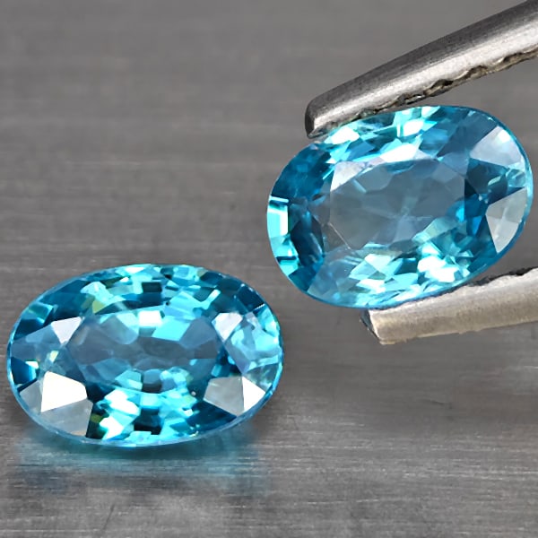 Natural Blue Zircon 1.43 Ct. 2 Pcs Oval Shape 6.2 x 4.2 Mm Gemstone from Cambodia: Product ID: 807725463 Product Name: Natural Zircon Weight: 1.43 CT. Size: 6.2 x 4.2 x 2.6 MM. Shape: Oval Shape Color: Blue Clarity:SI1 Luster: Good Gems Origin: Cambodia Treatment: Heated Crystal Str