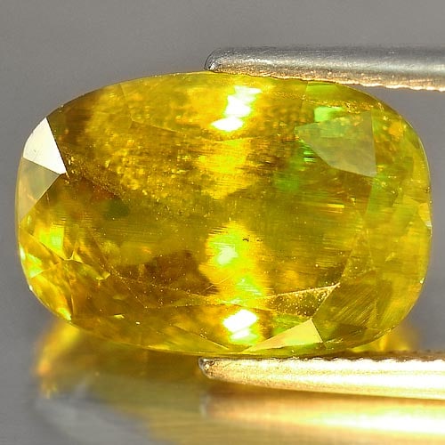 Natural Intense Green With Rainbow Spark Sphene 10.08 Ct. Cushion Shape 14.6 x 10 Mm. Gemstone from: Product ID: 806504163 Product Name: Natural Sphene Weight: 10.08 CT. Size: 14.6 x 10 x 8 MM. Shape: Cushion Color: Intense Green With Rainbow Clarity:VSI Luster: Adamantine Gems Origin: Madagascar Tre