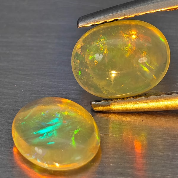 Natural Multi-Color Play Of Colour Opal 1.50 Ct. 2 Pcs Oval Cabochon Shape 7.4 x 6.4 Mm Gemstones: Product ID: 818728322 Product Name: Natural Opal Weight: 1.50 CT. Size: 7.4 x 6.4 x 2.9 MM. Shape: Oval Cabochon Color: Multi-Color Clarity:None Luster: Good Gems Origin: Ethiopia Treatment: Unheated
