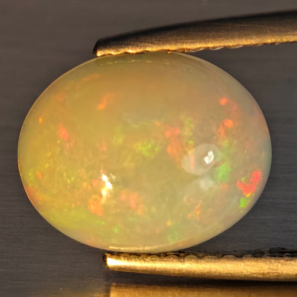 Natural Multi-Color Play Of Colour Opal Gemstone 2.10 Ct. Oval Cabochon Shape 11.2 x 9 Mm.: Product ID: 708700094 Product Name: Natural Opal Weight: 2.10 CT. Size: 11.2 x 9 x 4.7 MM. Shape: Oval Cabochon Color: Multi-Color Clarity:Opaque Luster: Good Gems Origin: Ethiopia Treatment: Unheated
