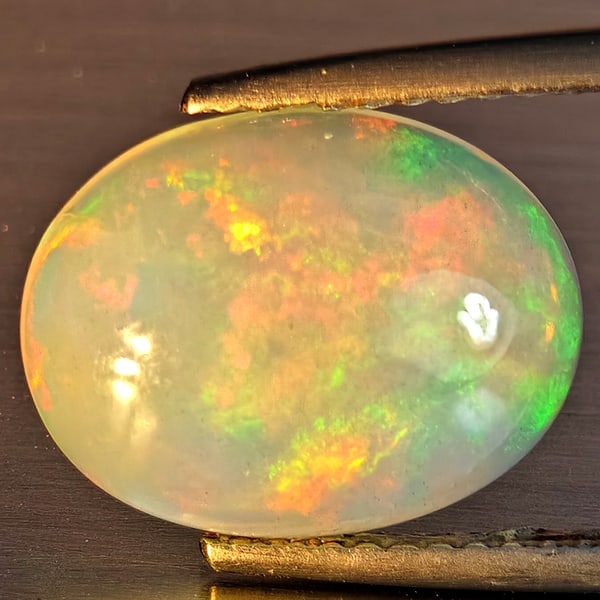 Natural Multi-Color Play Of Colour Opal Gemstones 2.58 Ct. Oval Cabochon Shape 13 x 10.2 Mm.: Product ID: 708700050 Product Name: Natural Opal Weight: 2.58 CT. Size: 13 x 10.2 x 4.3 MM. Shape: Oval Cabochon Color: Multi-Color Clarity:Opaque Luster: Good Gems Origin: Ethiopia Treatment: Unheate