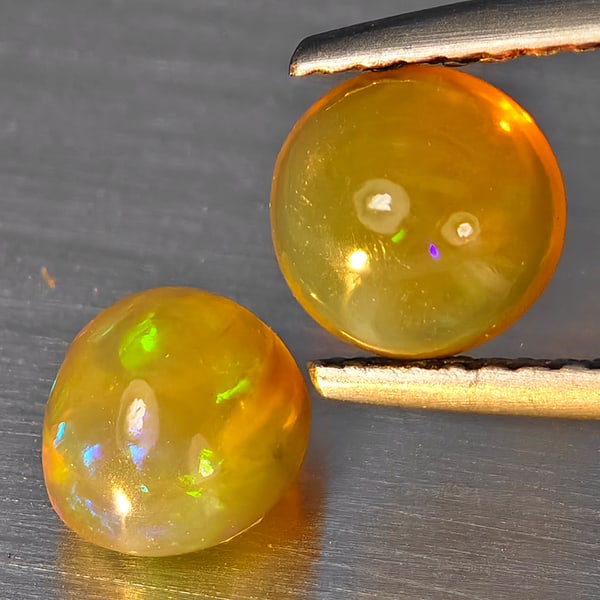 Natural Multi Color Play Of Colour Opal Gemstones 1.62 Ct. 2 Pcs Mixed Cabochon Shape Mixed Size: Product ID: 818728348 Product Name: Natural Opal Weight: 1.62 CT. Size: 6.6 x 5.5 x 5.1 to 6.2 x 6.2 x 4 MM. Shape: Mixed Shape Color: Multi-Color Clarity:None Luster: Good Gems Origin: Ethiopia Treat