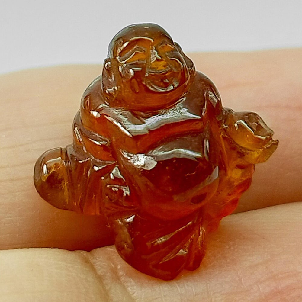 Natural Orange Spessartine Garnet 12.07 Ct. Very Happy Buddha Carving 13.5 x 13 Mm.: Product ID: 501200054 Product Name: Natural Spessartine Weight: 12.07 CT. Size: 13 x 13.5 x 13 MM. Shape: Carving Color: Orange Honey Natural Color Clarity:None Luster: Good Carving Gems Origin: Namib
