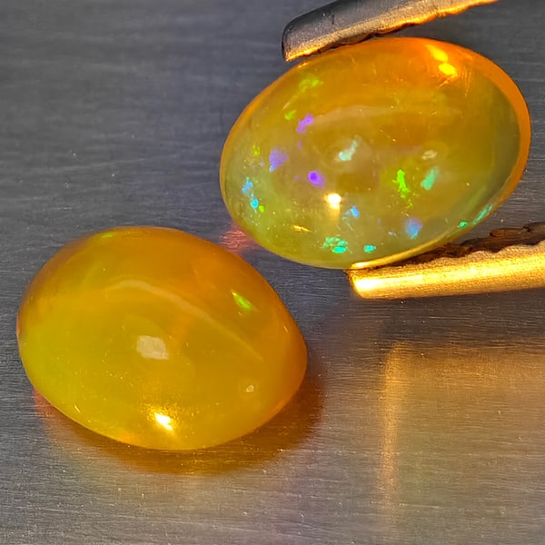 Natural Multi Color Play Of Colour Opal Gemstones 1.34 Ct. 2 Pcs. Oval Cabochon Shape 7.5 x 5.3 Mm.: Product ID: 818728360 Product Name: Natural Opal Weight: 1.34 CT. Size: 7.5 x 5.3 x 3.7 MM. Shape: Oval Cabochon Color: Multi-Color Clarity:None Luster: Good Gems Origin: Ethiopia Treatment: Unheated 