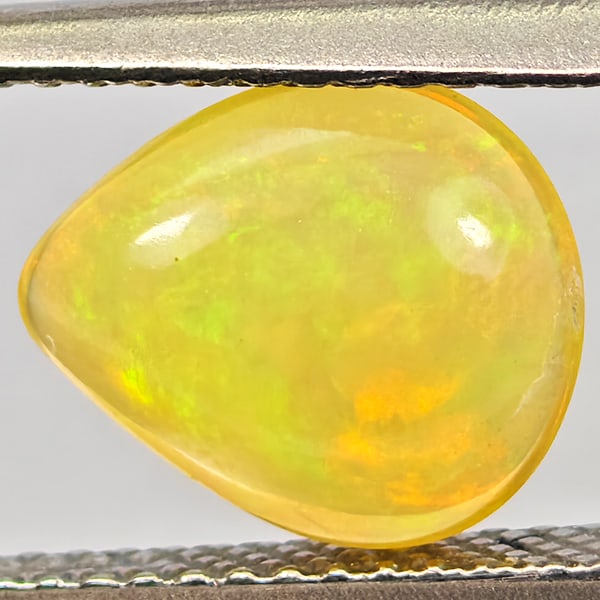 Natural Multi-Color Flashing Play Of Colour Opal Gemstones 0.94 Ct. Pear Cabochon Shape 9.6 x 8.2: Product ID: 818728052 Product Name: Natural Opal Weight: 0.94 CT. Size: 9.6 x 8.2 x 2.8 MM. Shape: Pear Cabochon Color: Multi-Color Clarity:Semi - Transparent Luster: Good Gems Origin: Ethiopia Treatm