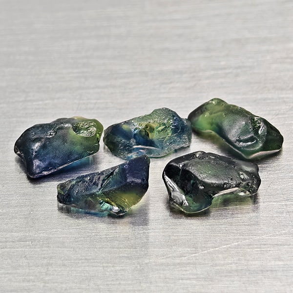 Natural Unheated Greenish Blue Sapphire Gemstones 3.17 Ct. 5 Pcs Rough Shape Mixed Size: Product ID: 806162518 Product Name: Natural Green Sapphire Weight: 3.17 CT. Size: 6.1 x 2.8 x 3.1 to 6.7 x 4.4 x 3.2 MM. Shape: Rough Mixed Shape Color: Greenish Blue Clarity:VSI Luster: Good Gems Ori