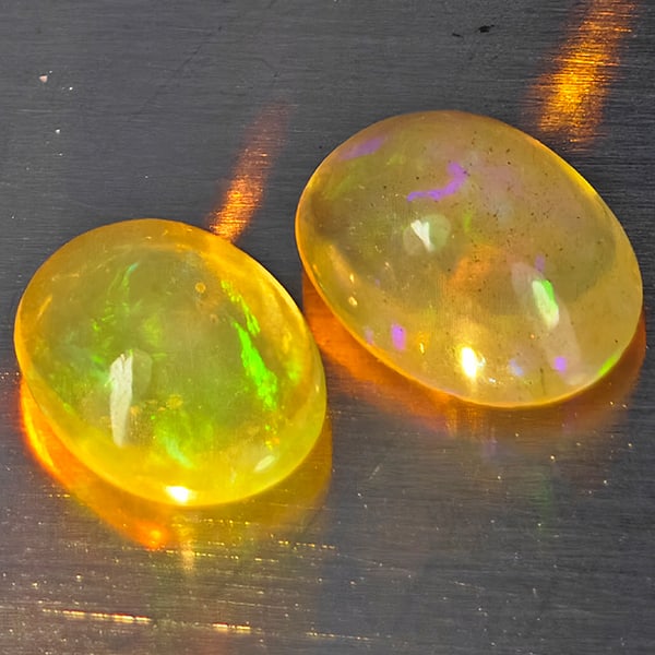 Natural Multi-Color Play Of Colour Opal Gemstones 1.55 Ct. 2 Pcs. Oval Cabochon Shape 7.6 x 5.8 Mm.: Product ID: 818728294 Product Name: Natural Opal Weight: 1.55 CT. Size: 7.6 x 5.8 x 3.5 MM. Shape: Oval Cabochon Color: Multi-Color Clarity:None Luster: Good Gems Origin: Ethiopia Treatment: Unheated 
