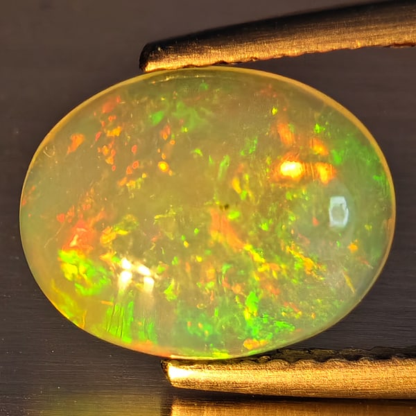 Natural Multi-Color Play Of Colour Opal Gemstone 1.68 Ct. Oval Cabochon Shape 10.5 x 8.4 Mm.: Product ID: 708700225 Product Name: Natural Opal Weight: 1.68 CT. Size: 10.5 x 8.4 x 4.1 MM. Shape: Oval Cabochon Color: Multi-Color Clarity:Opaque Luster: Good Gems Origin: Ethiopia Treatment: Unheat