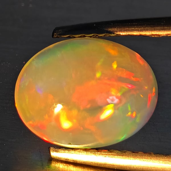 Natural Multi-Color Play Of Colour Opal Gemstone 1.72 Ct. Oval Cabochon Shape 10 x 7.8 Mm.: Product ID: 708700140 Product Name: Natural Opal Weight: 1.72 CT. Size: 10 x 7.8 x 4.6 MM. Shape: Oval Cabochon Color: Multi-Color Clarity:Opaque Luster: Good Gems Origin: Ethiopia Treatment: Unheated