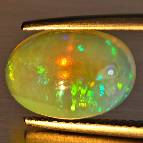 Natural Multi-Color Play Of Colour Opal Gemstone 4.15 Ct. Oval Cabochon Shape 13.3 x 9.4 Mm.: Product ID: 708700143 Product Name: Natural Opal Weight: 4.15 CT. Size: 13.3 x 9.4 x 6.3 MM. Shape: Oval Cabochon Color: Multi-Color Clarity:Opaque Luster: Good Gems Origin: Ethiopia Treatment: Unheat