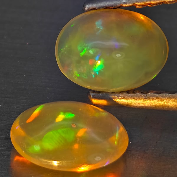 Natural Multi-Color Play Of Colour Opal Gemstones 1.16 Ct. 2 Pcs. Oval Cabochon Shape 7 x 5.1 Mm.: Product ID: 818728281 Product Name: Natural Opal Weight: 1.16 CT. Size: 7 x 5.1 x 3.5 MM. Shape: Oval Cabochon Color: Multi-Color Clarity:None Luster: Good Gems Origin: Ethiopia Treatment: Unheated Cr