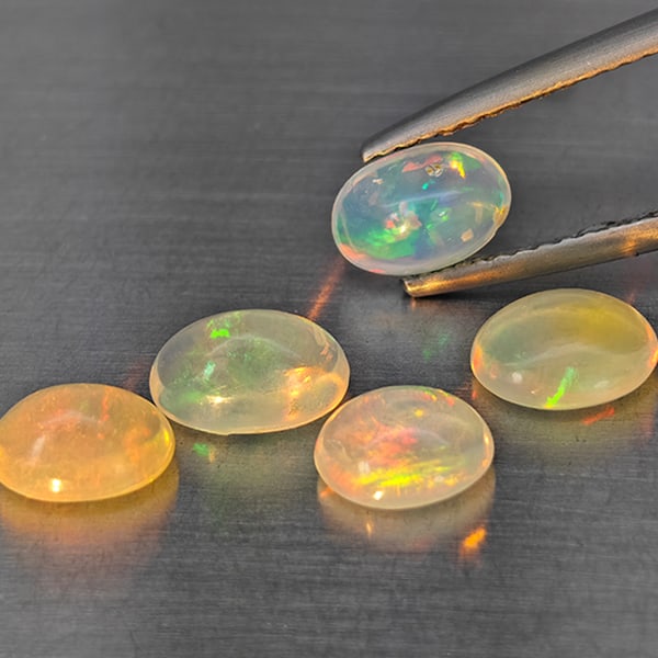 Natural Multi-Color Play Of Colour Opal Gemstones 2.68 Ct. 5 Pcs. Oval Cabochon Shape 7.4 x 5 Mm.: Product ID: 818728334 Product Name: Natural Opal Weight: 2.68 CT. Size: 7.4 x 5 x 4.2 to 6.5 x 5.4 x 3.1 MM. Shape: Oval Cabochon Color: Multi-Color Clarity:None Luster: Good Gems Origin: Ethiopia Tre