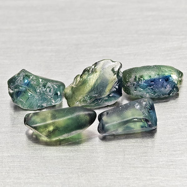 Natural Unheated Greenish Blue Sapphire Gemstones 3.88 Ct. 5 Pcs. Rough Shape and Mixed Size: Product ID: 806162538 Product Name: Natural Green Sapphire Weight: 3.88 CT. Size: 6.4 x 4.3 x 2.5 to 8.1 x 3.6 x 3 MM. Shape: Rough Mixed Shape Color: Greenish Blue Clarity:VSI Luster: Good Gems Origi