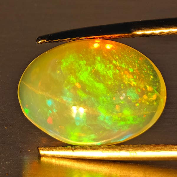 Natural Multi-Color Play Of Colour Opal Gemstone 4.35 Ct. Oval Cabochon Shape 14 x 10 Mm.: Product ID: 708700126 Product Name: Natural Opal Weight: 4.35 CT. Size: 14 x 10 x 7 MM. Shape: Oval Cabochon Color: Multi-Color Clarity:Opaque Luster: Good Gems Origin: Ethiopia Treatment: Unheated Cr