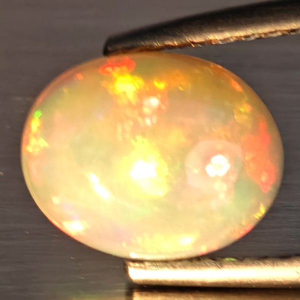 Natural Multi-Color Play Of Colour Opal Gemstone 1.96 Ct. Oval Cabochon Shape 9.7 x 7.8 Mm.: Product ID: 708700148 Product Name: Natural Opal Weight: 1.96 CT. Size: 9.7 x 7.8 x 4 MM. Shape: Oval Cabochon Color: Multi-Color Clarity:Opaque Luster: Good Gems Origin: Ethiopia Treatment: Unheated 