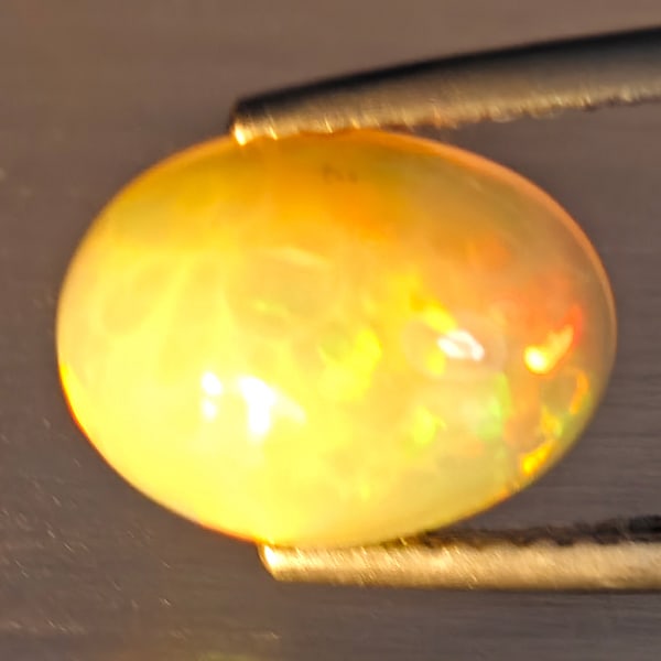 Natural Multi-Color Play Of Colour Opal Gemstone 2.19 Ct. Oval Cabochon Shape 10.9 x 8.4 Mm.: Product ID: 708700124 Product Name: Natural Opal Weight: 2.19 CT. Size: 10.9 x 8.4 x 5 MM. Shape: Oval Cabochon Color: Multi-Color Clarity:Opaque Luster: Good Gems Origin: Ethiopia Treatment: Unheated