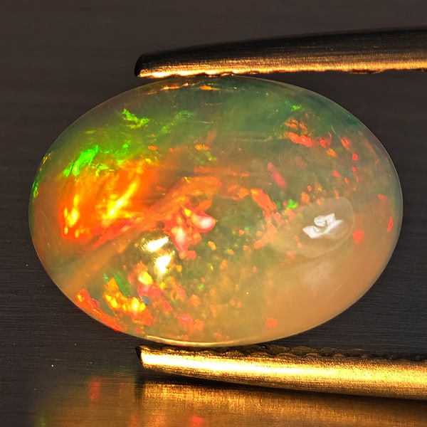 Natural Multi-Color Play Of Colour Opal Gemstone 2.10 Ct. Oval Cabochon Shape 12 x 8.9 Mm.: Product ID: 708700158 Product Name: Natural Opal Weight: 2.10 CT. Size: 12 x 8.9 x 4.3 MM. Shape: Oval Cabochon Color: Multi-Color Clarity:Opaque Luster: Good Gems Origin: Ethiopia Treatment: Unheated