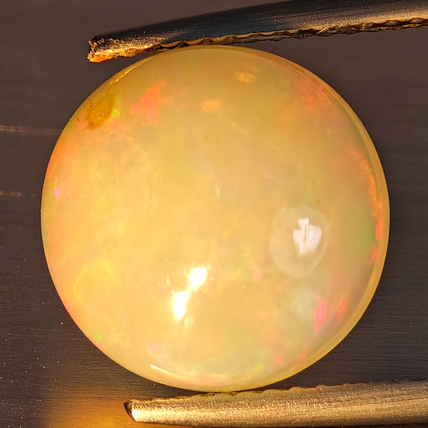 Natural Multi-Color Play Of Colour Opal Gemstone 4.30 Ct. Round Cabochon Shape 11.8 Mm.: Product ID: 708700047 Product Name: Natural Opal Weight: 4.30 CT. Size: 11.8 x 11.8 x 6.8 MM. Shape: Round Cabochon Color: Multi-Color Clarity:Opaque Luster: Good Gems Origin: Ethiopia Treatment: Unhe