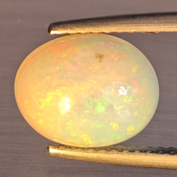 Natural Multi-Color Play Of Colour Opal Gemstone 1.88 Ct. Oval Cabochon Shape 10.5 x 8.6 Mm.: Product ID: 708700026 Product Name: Natural Opal Weight: 1.88 CT. Size: 10.5 x 8.4 x 4.7 MM. Shape: Oval Cabochon Color: Multi-Color Clarity:Opaque Luster: Good Gems Origin: Ethiopia Treatment: Unheat