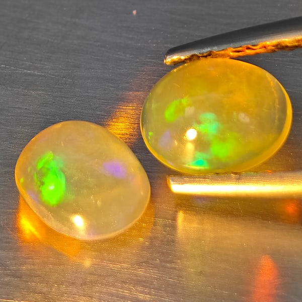 Natural Multi-Color Play Of Colour Opal Gemstones 1.48 Ct. 2 Pcs. Oval Cabochon Shape 7.4 x 5.6 Mm.: Product ID: 818728321 Product Name: Natural Opal Weight: 1.48 CT. Size: 7.4 x 5.6 x 4 MM. Shape: Oval Cabochon Color: Multi-Color Clarity:None Luster: Good Gems Origin: Ethiopia Treatment: Unheated Cr