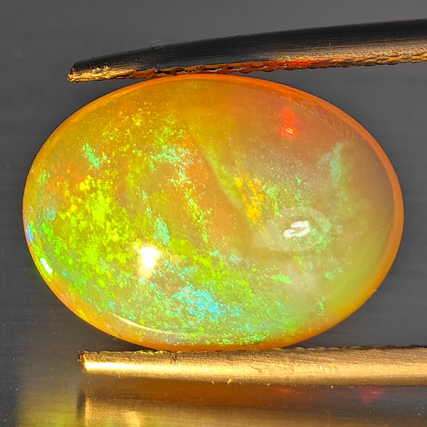 Natural Multi-Color Play Of Colour Opal Gemstone 4.67 Ct. Oval Cabochon Shape 14.4 x 10.6 Mm.: Product ID: 708700174 Product Name: Natural Opal Weight: 4.67 CT. Size: 14.4 x 10.6 x 7.1 MM. Shape: Oval Cabochon Color: Multi-Color Clarity:Opaque Luster: Good Gems Origin: Ethiopia Treatment: Unhea