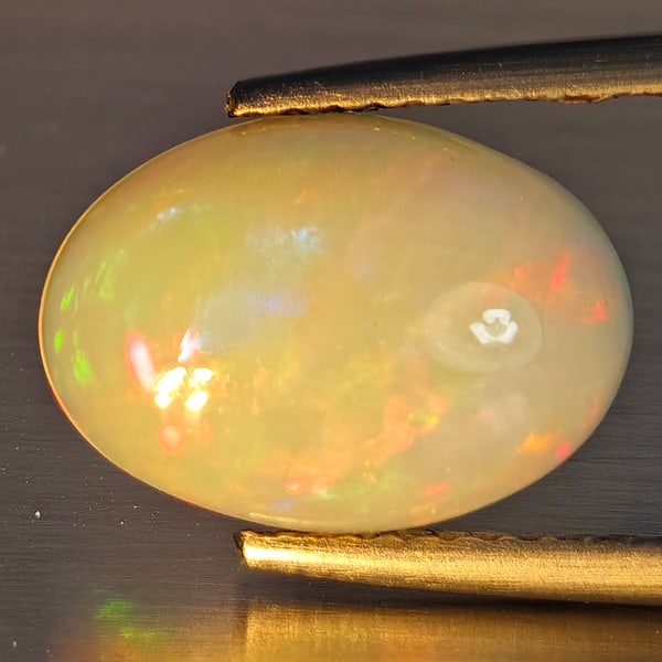 Natural Multi-Color Opal Gemstone 1.97 Ct. Oval Cabochon Shape 12.5 x 9 Mm.: Product ID: 708700224 Product Name: Natural Opal Weight: 1.97 CT. Size: 12.5 x 9 x 4.1 MM. Shape: Oval Cabochon Color: Multi-Color Clarity:Opaque Luster: Good Gems Origin: Ethiopia Treatment: Unheated