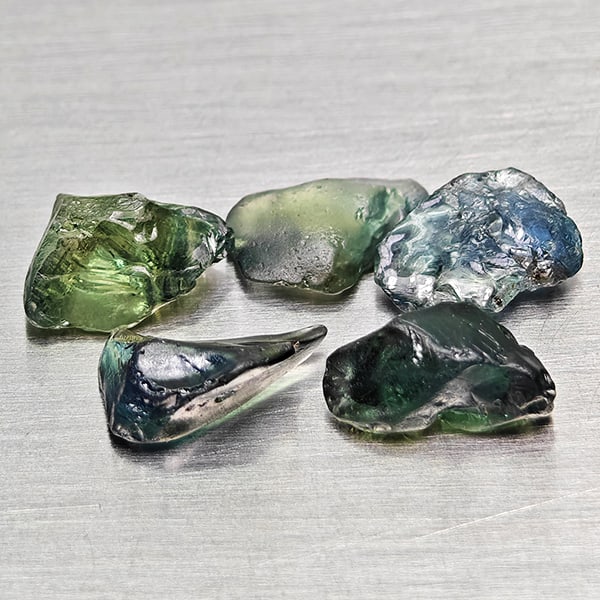 Natural Greenish Blue Sapphire Gemstones 3.94 Ct. 5 Pcs. Rough Shape: Product ID: 806162516 Product Name: Natural Green Sapphire Weight: 3.94 CT. Size: 7 x 5.4 x 2 to 7.5 x 4.9 x 3.3 MM. Shape: Rough Mixed Shape Color: Greenish Blue Clarity:VSI Luster: Good Gems Origin: