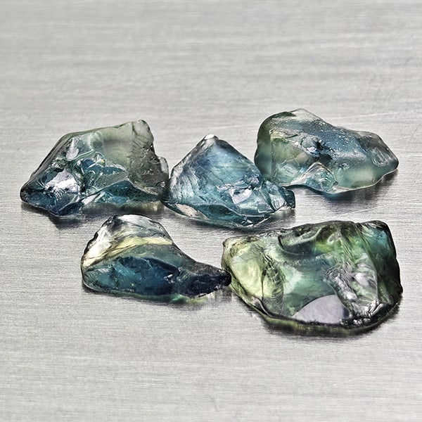 Natural Unheated Greenish Blue Sapphire Gemstones 2.78 Ct. 5 Pcs. Rough Shape Mixed Size: Product ID: 806162519 Product Name: Natural Green Sapphire Weight: 2.78 CT. Size: 6 x 3.8 x 2.7 to 7.8 x 6.2 x 2.1 MM. Shape: Rough Mixed Shape Color: Greenish Blue Clarity:VSI Luster: Good Gems Origi