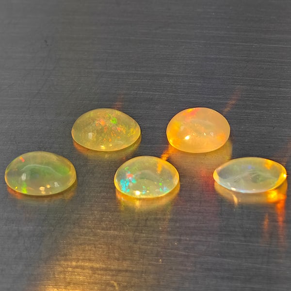 Natural Multi-Color Play Of Colour Opal Gemstones 2.11 Ct. 5 Pcs. Oval Cabochon Shape 6.7 x 5 Mm.: Product ID: 818728337 Product Name: Natural Opal Weight: 2.11 CT. Size: 6.7 x 5 x 2.9 to 5.8 x 4.9 x 2.6 MM. Shape: Oval Cabochon Color: Multi-Color Clarity:None Luster: Good Gems Origin: Ethiopia Tre