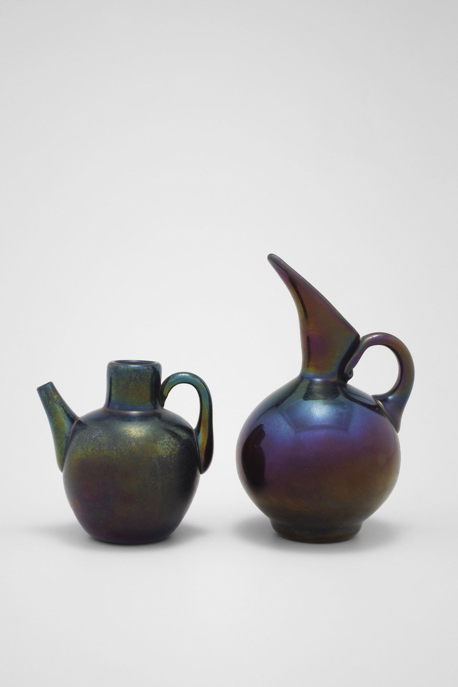 Thomas Webb & Sons - Design likely by Christopher Dresser (British, 1834 - 1904): Iridescent Bronze Glass Ewer - c.1880 Glass, 11 cm Thomas Webb & Sons worked in the Stourbridge area near Birmingham and some of their designs were made by Christopher Dresser. The classical shape of