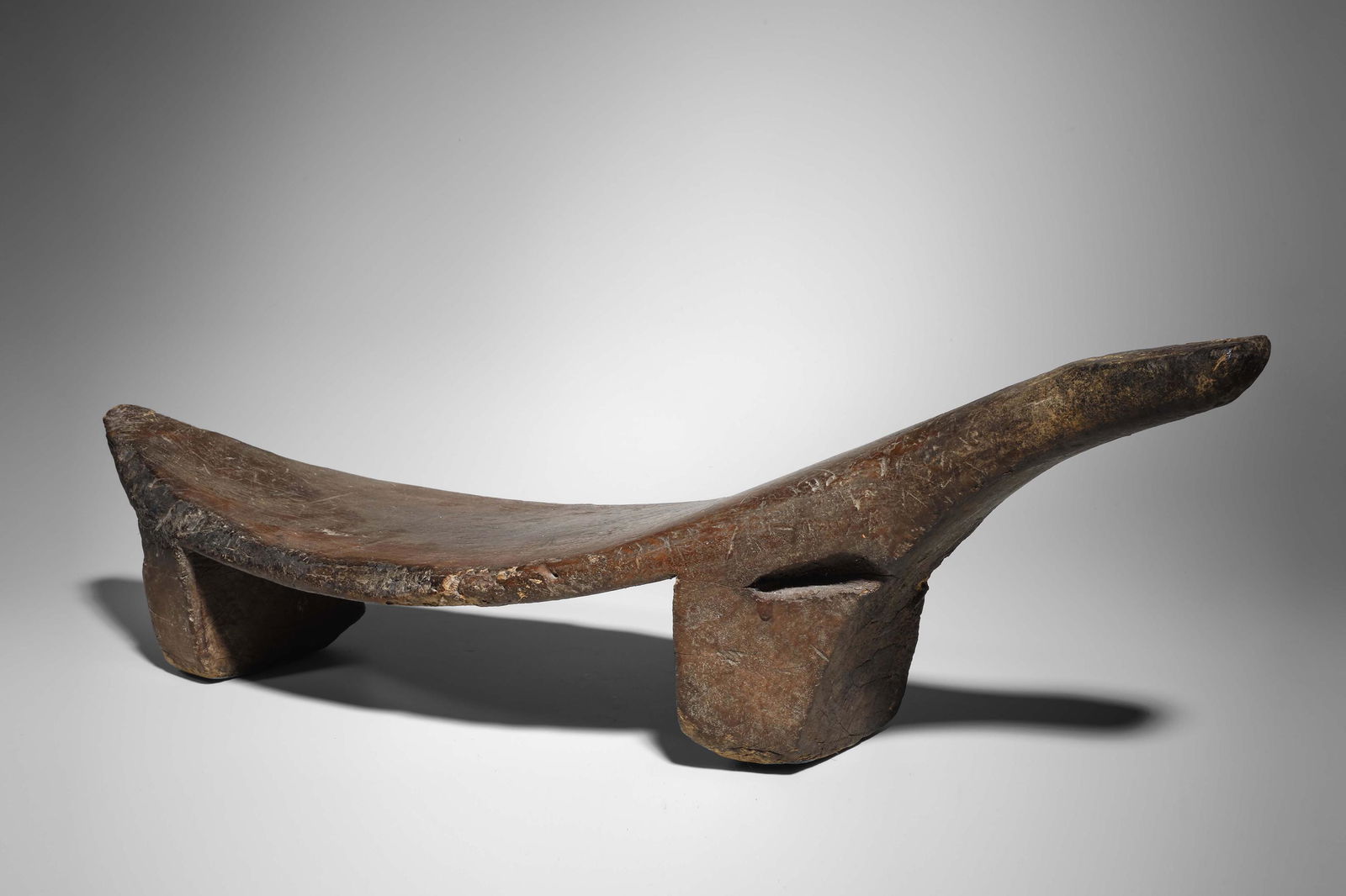 Kana-Akari - Coconut Grating Stool: Caroline Islands, Nukuoro, Micronesia Wood, 72,5 cm Provenance: Property from a Princely collection The rudimentary shape and deep patina of this coconut grating stool bear witness to its age. The ele