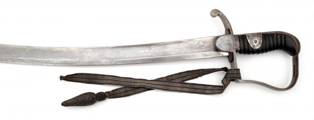 The Pattern 1796 Light Cavalry Saber or M 1811: The broad curved flat backed blade with a broad single fuller to each side. The stirrup hilted guard has a slot for a sword knot (is present) near the plain pommel. Leather covered wood grip and backs