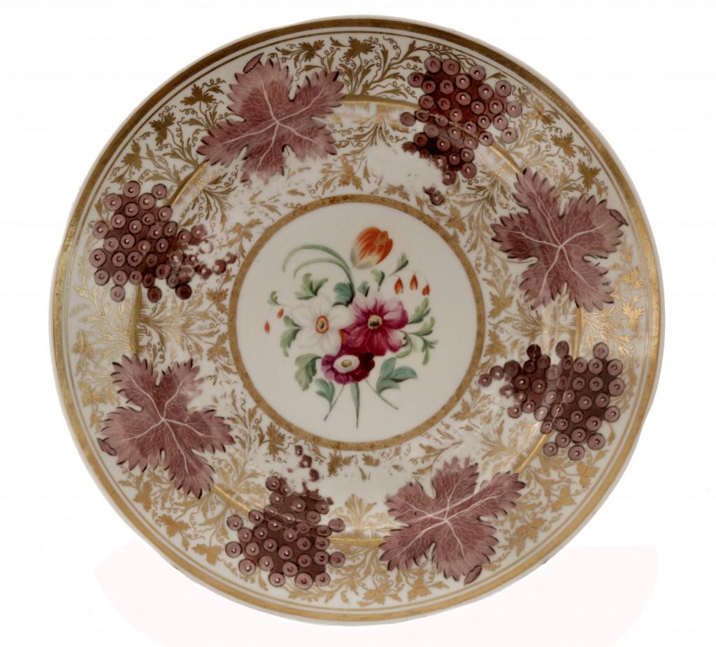 A Russian Plate: Porcelain, slightly profiled wide rim with broad and thin gold bands is decorated with gold painted branches with purple grapes and leaves. The mirror is decorated with colorful blossoms with green fo