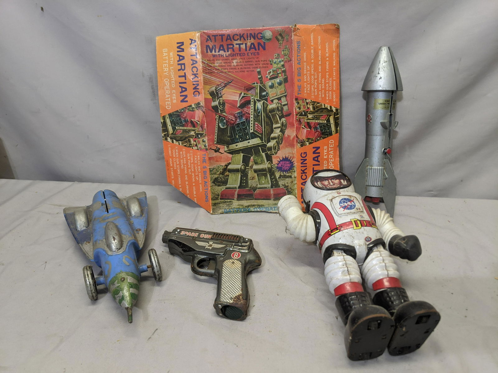Lot 5 c1950's Toys Rockets Space Gun Astronaut Robot: Lot 5 c1950's Toys including a rocket bank, rocket car, NASA astronaut, attacking martian partial box lid Shipping in continental US $15.00 If shipping is $0 then buyer arranges pick up or shipping. P