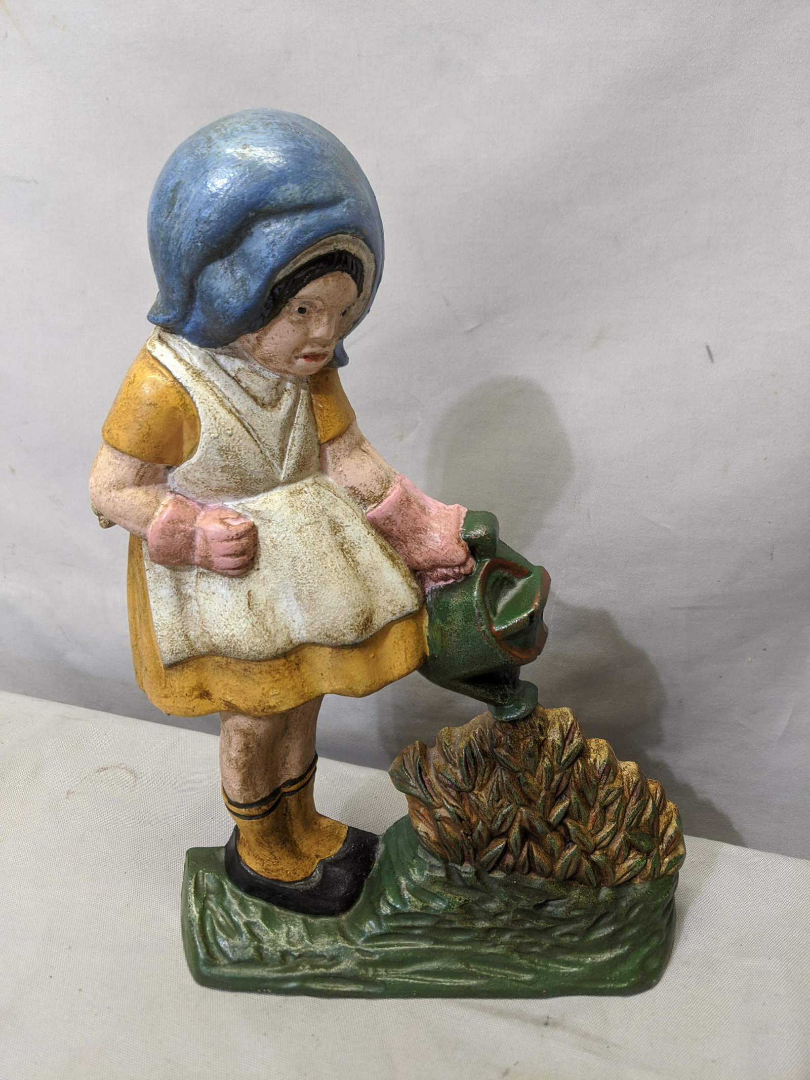 Vintage Girl Watering Corn Cast Iron Door Stop: Vintage Girl Watering Corn Cast Iron Door Stop 11 1/2 high Shipping in continental US $17.00 If shipping is $0 then buyer arranges pick up or shipping. Please ask any questions before bidding Good Luc