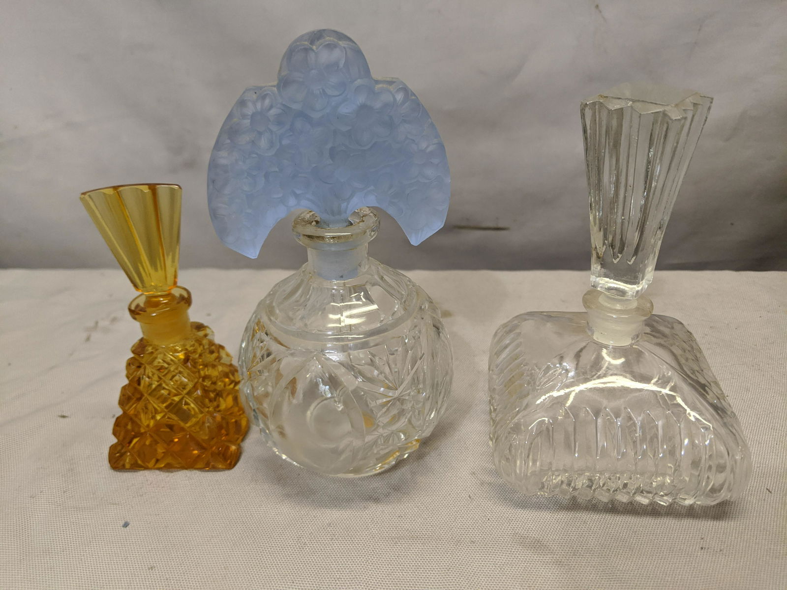 Lot 3 Vintage Glass Perfume Bottles: Lot 3 Vintage Glass Perfume Bottles, signed amber, Czech with blue stopper and Japan clear. Measurements in inches:4, 5 and 8 1/2 high We offer in-house shipping. Item(s) will be packed after invoice