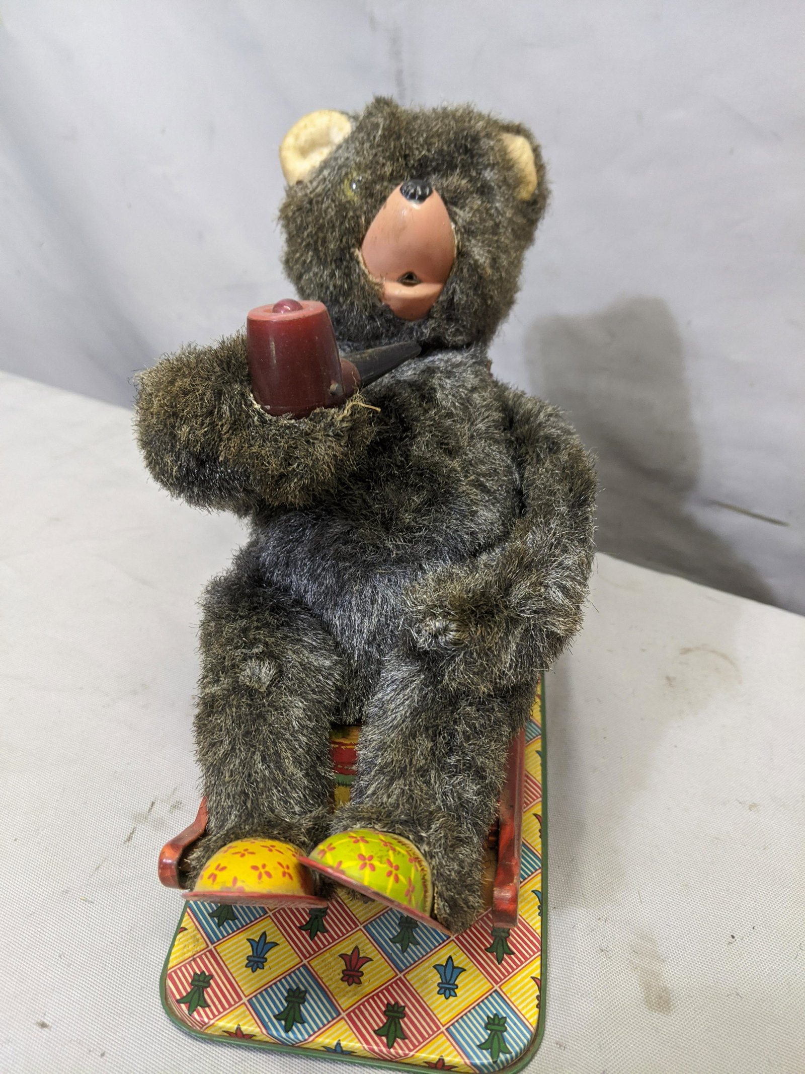 c1950's Japan Tin Litho Battery-Op Bear in Rocker w/: c1950's Japan Tin Litho Battery-Op Bear in Rocker w/ Pipe. Measurements in inches:9 high We offer in-house shipping. Item(s) will be packed after invoice is paid and shipping cost will be collected se