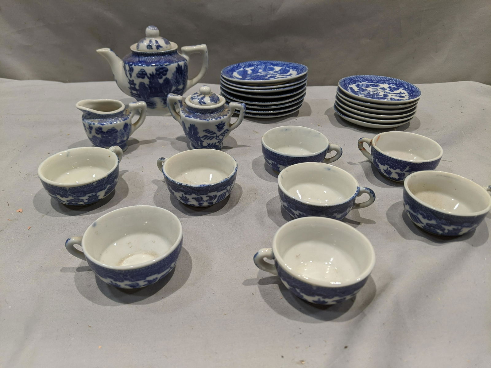 25 pcs Blue Willow Japan Pottery Doll Tea Set: 25 pcs Blue Willow Japan Pottery Doll Tea Set with 8 cups, tea pot, creamer, sugar, 6 bowls and 8 saucers. Made in Occupied Japan. Condition:Two cup have repaired chips Shipping:We offer in-house ship