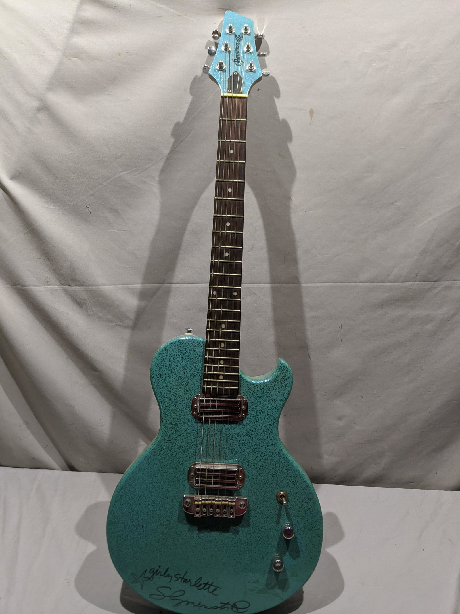 Brownsville Thug Aquamarine Metalflake Electric Guitar: Brownsville Thug Aquamarine Metalflake Electric Guitar with signature on front. Measurements in inches: 38 long Condition:Mild wear with age and use, Has not been tested Shipping:We offer in-house shi