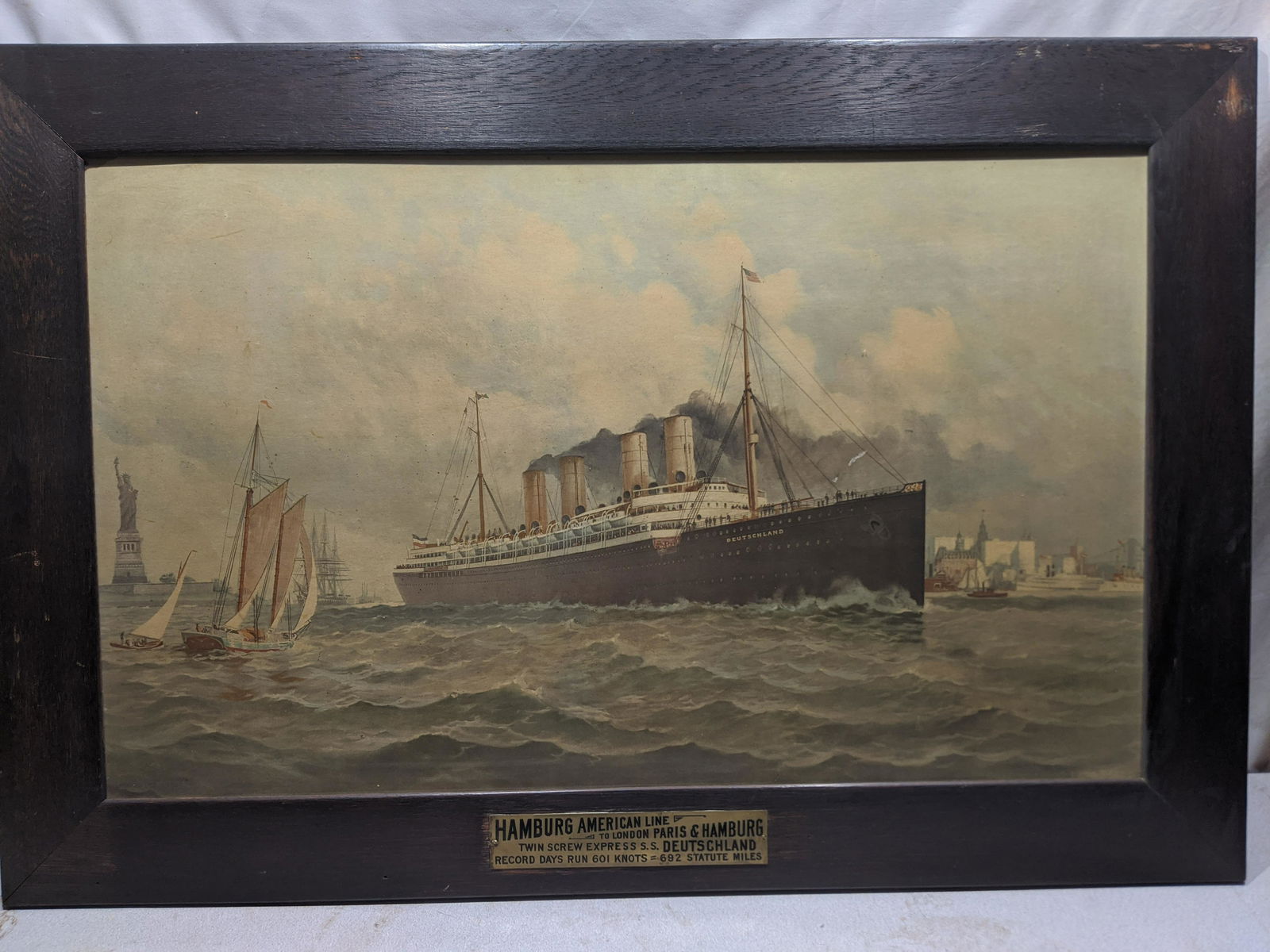 Deutschland Hamburg American Line Steamship Print: Deutschland Hamburg American Line Steamship Print in original wood frame. Measurements in inches: 47 x 32, Image: 39 x 24 Condition:Has some mild soiling and wear to frame Shipping:We offer in-house s