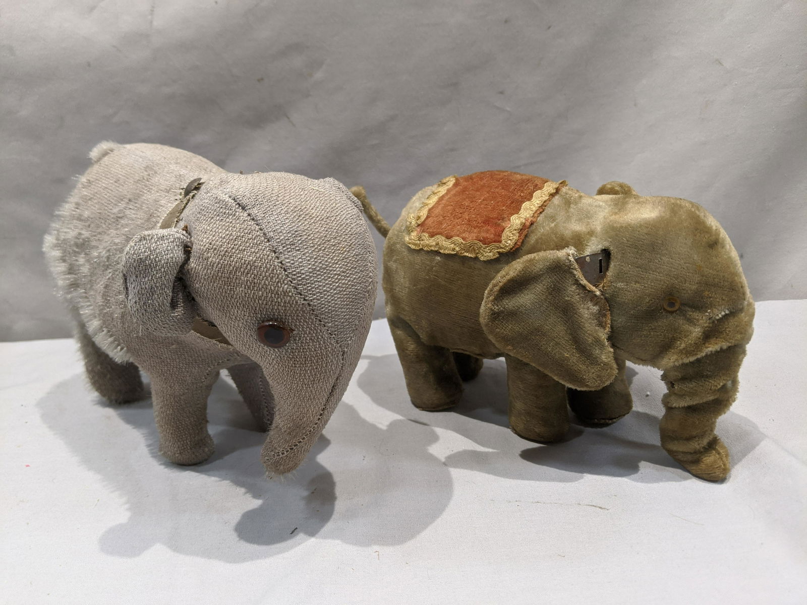 Lot 2 Antique Steiff & Wind-OP Elephant Toys: Lot 2 Antique Steiff & Wind-OP Elephant Toys. Measurements in inches: 7 and 8 long Condition:Well worn with age, missing and eye on one and tusk on other. Wind up not tested Shipping:We offer in-house